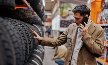 mężczyzna sprawdzający minimalną głębokość bieżnika opony
