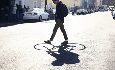 mężczyzna przechodzi po nasłonecznionej ulicy