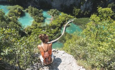 Kobieta podziwiająca krajobraz Parku Narodowego Jezior Plitwickich z krawędzi klifu