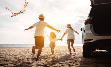 rodzina na wakacjach, wybiegająca z samochodu na plażę