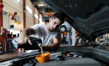mężczyzna sprawdzający odmę olejową w samochodzie