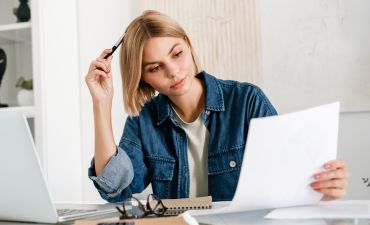 kobieta czytający dokumenty przy biurku