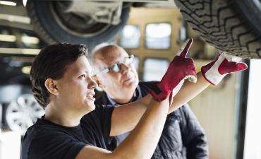 dwóch mężczyzn sprawdza indeks prędkości opon