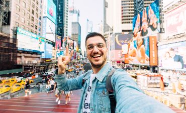 mężczyzna robiący selfie na Times Square
