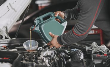 Kierowca wlewa olej do silnika