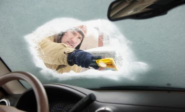 mężczyzna odśnieża samochód