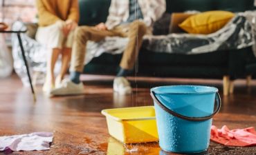 wiadro i miska stojące na zalanej podłodze