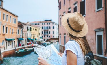 podróżująca kobieta odczytująca mapę, w tle kanały Wenecji