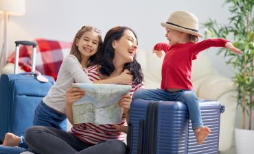 Kobieta z dwójką małych dzieci, bagażami i mapą