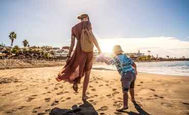 kobieta z dzieckiem za rękę na plaży