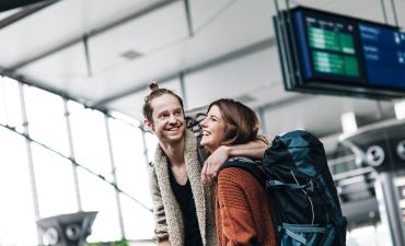 para na lotnisku przy tablicy odlotów