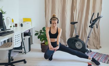 Dziewczyna w słuchawkach ćwicząca w swoim pokoju