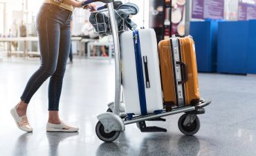 pasażerka z wózkiem i walizkami na lotnisku