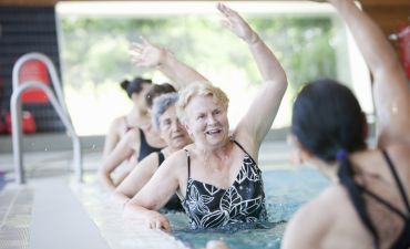 Kilka kobiet trenuje w basenie w sanatorium