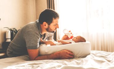 Mężczyzna karmi butelką noworodka