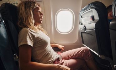 kobieta siedząca w samolocie, bojąca się latać