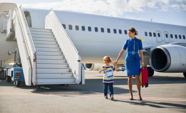 dziecko wychodzące z samolotu odprowadzane prze stewardesę