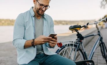 siedzący mężczyzna z telefonem i rowerem