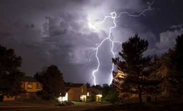 domy na tle burzy z piorunami