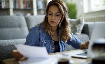 Kobieta czytająca dokumenty przy biurku