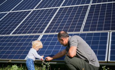 mężczyzna i małe dziecko naprawiają kolektor fotowoltaiczny