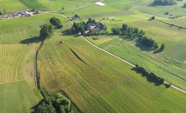 Widok z góry na ziemię działkę rolną z zabudowaniami