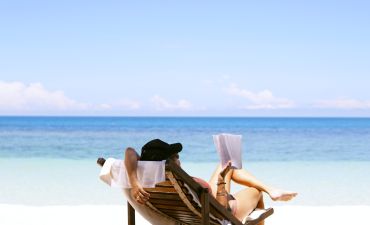 Kobieta czytająca na plaży, na leżaku