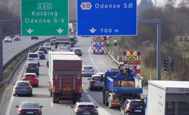 Auta z Danii i znaki drogowe nad autostradą w