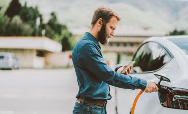 Mężczyzna ładuje samochód elektryczny